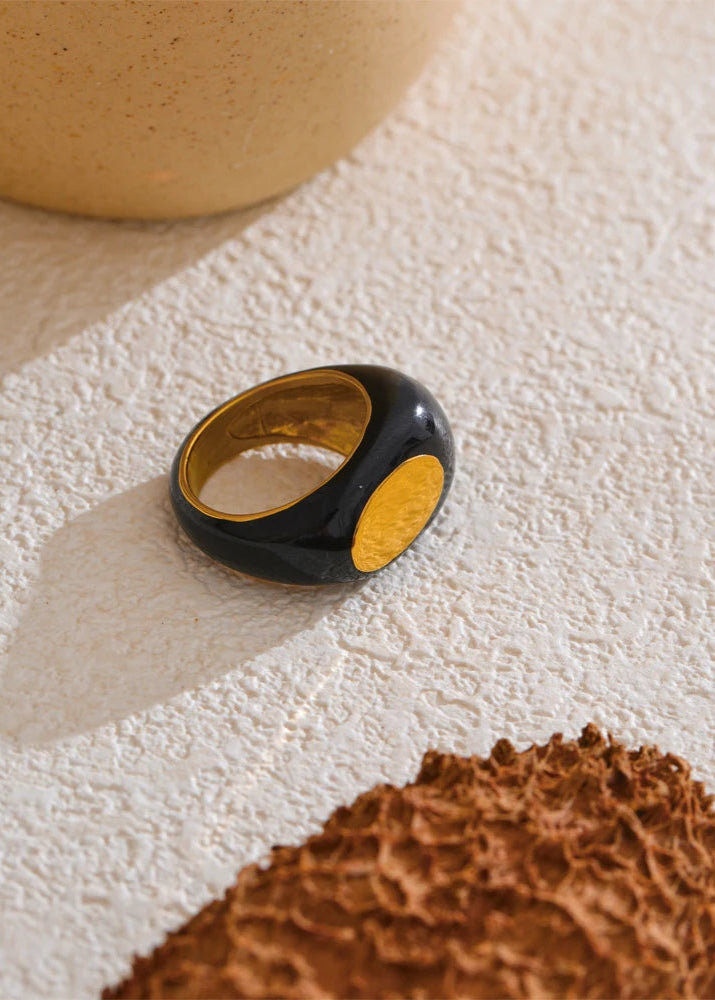 Black and gold ring on a textured surface