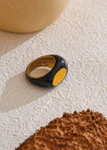 Black and gold ring on a textured surface