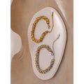 Two bracelets on a white stone surface with a beige background