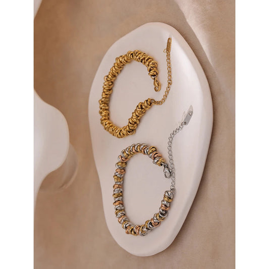 Two bracelets on a white stone surface with a beige background