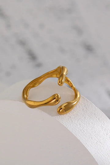 Gold ring on a white stone surface with a marble background