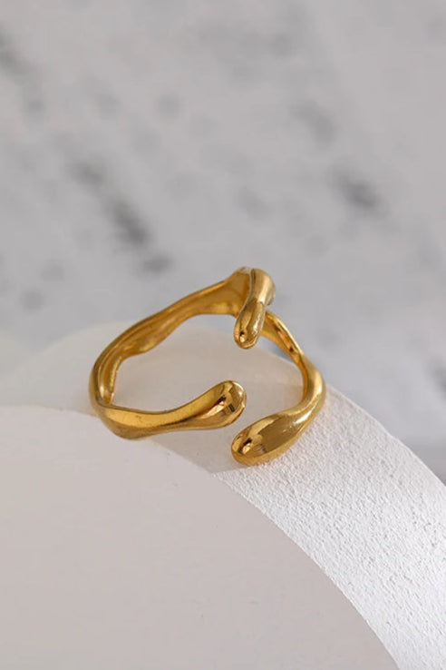 Gold ring on a white stone surface with a marble background
