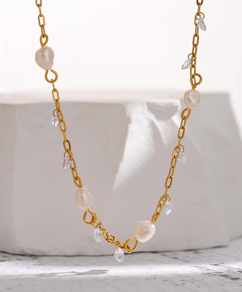 Gold chain necklace with pearls on a white background