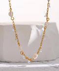 Gold chain necklace with pearls on a white background