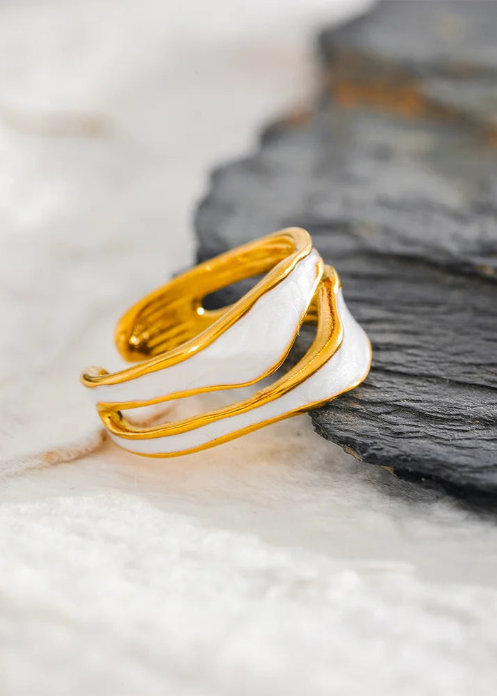 Gold and white ring on a textured surface