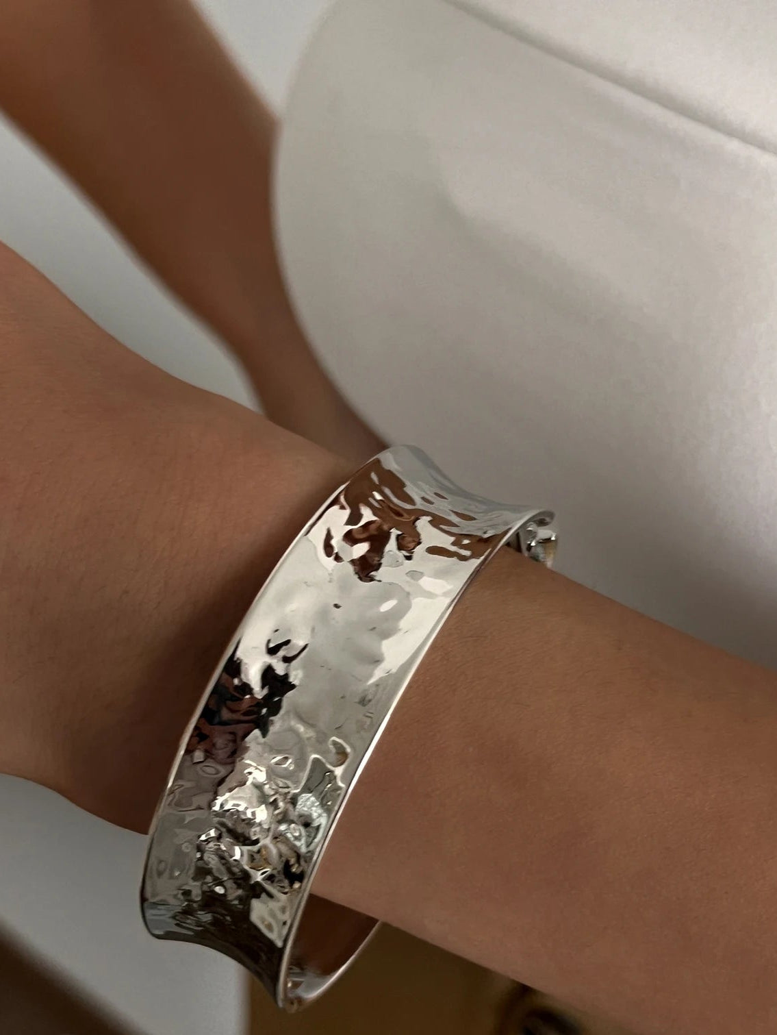 Silver bracelet on a wrist with a blurred background