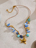 Necklace with blue and gold beads on a textured white surface