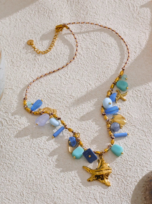 Necklace with blue and gold beads on a textured white surface