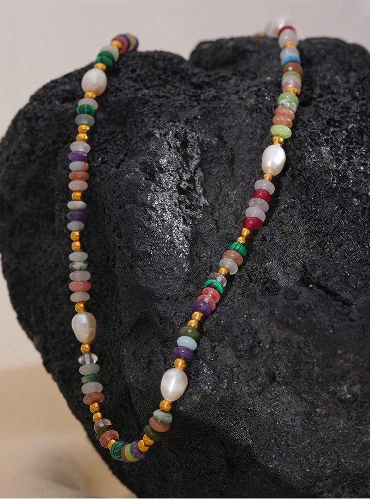 Multicolored beaded necklace on a dark stone surface