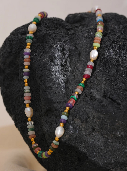 Multicolored beaded necklace on a dark stone surface