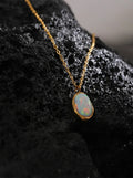 Opal pendant necklace on a dark textured surface