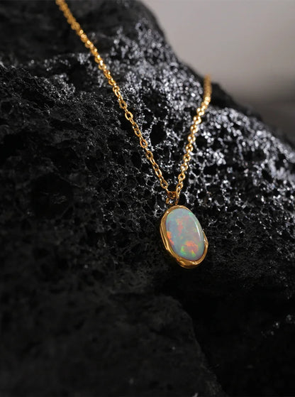Opal pendant necklace on a dark textured surface