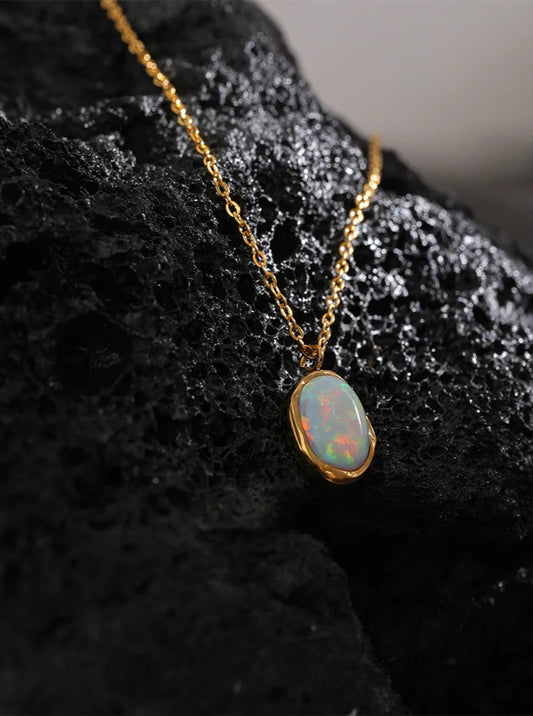 Opal pendant necklace on a dark textured surface