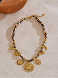 Leopard print Necklace with gold and black beads and charms on a light background