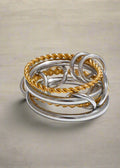 Stack of silver and gold rings on a white background