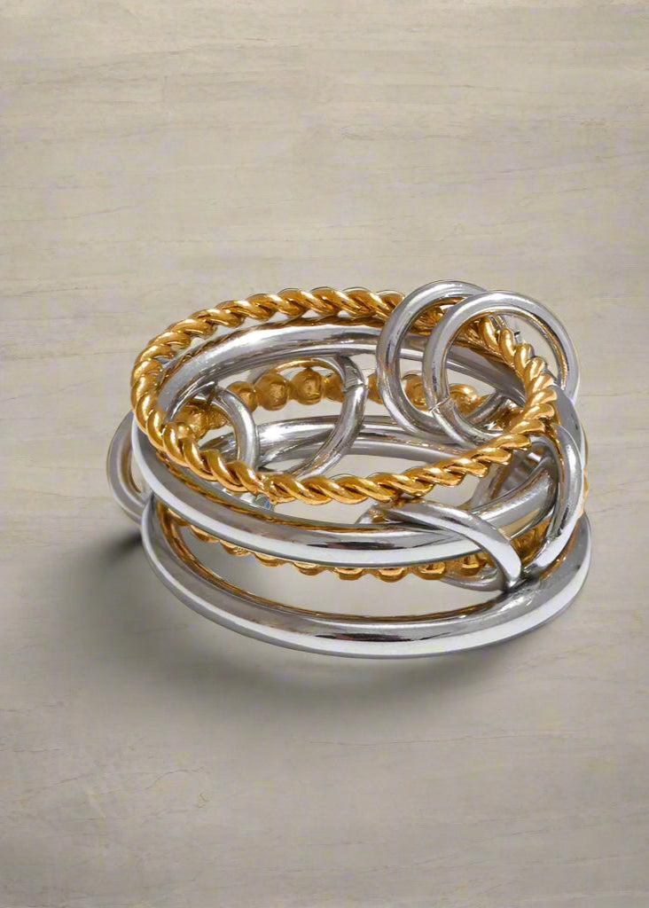 Stack of silver and gold rings on a white background