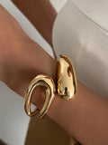 Gold bracelet on a wrist with a blurred background