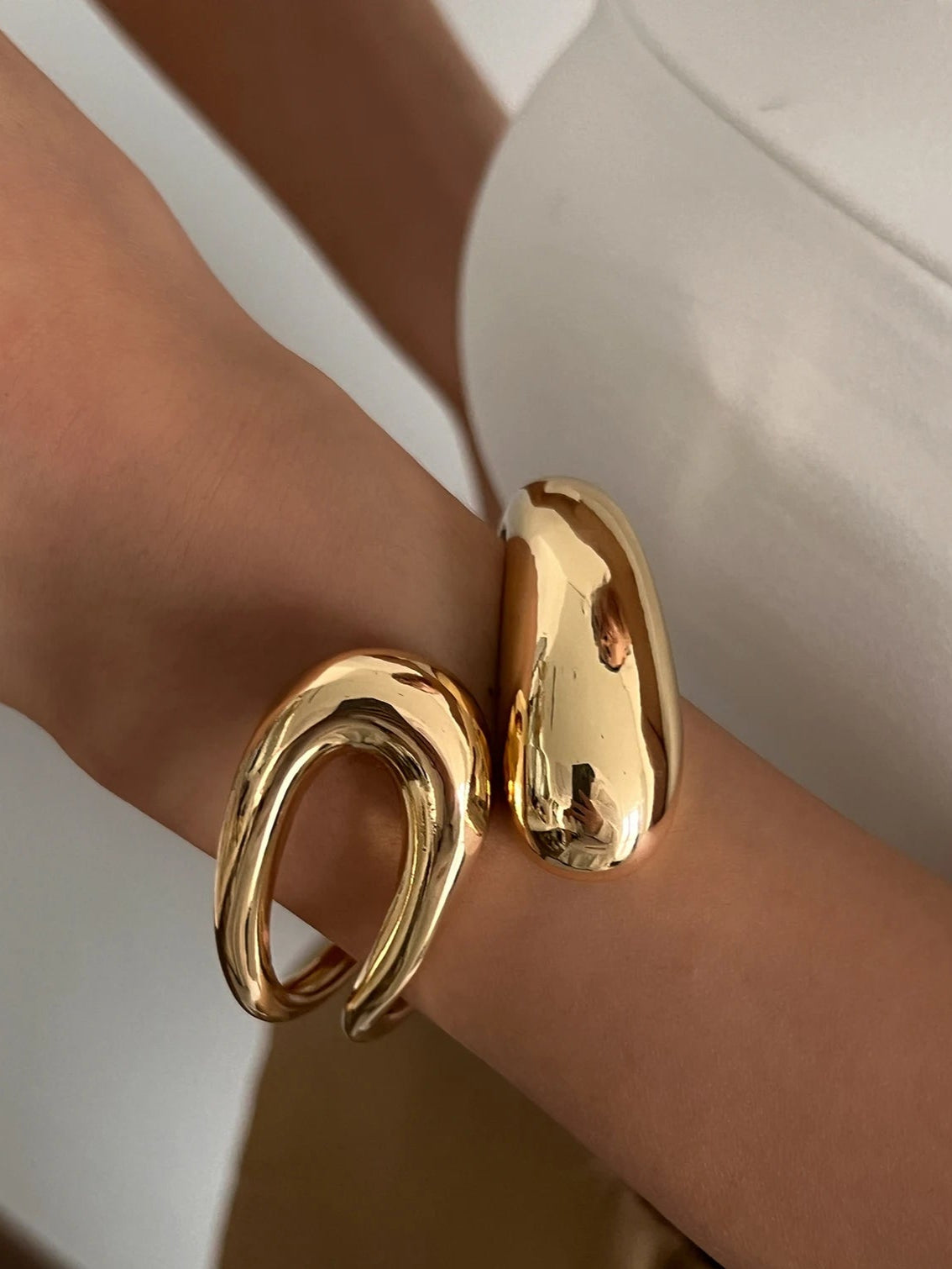 Gold bracelet on a wrist with a blurred background