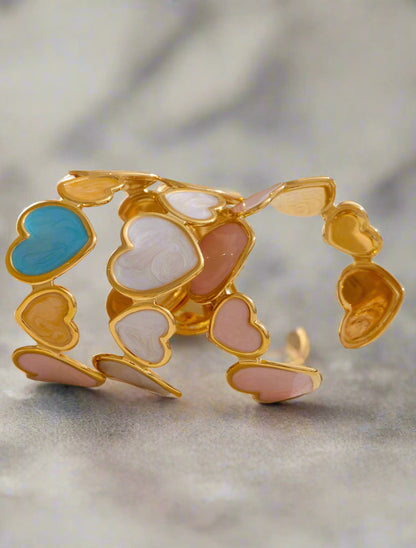 Gold bracelet with heart-shaped charms on a light background