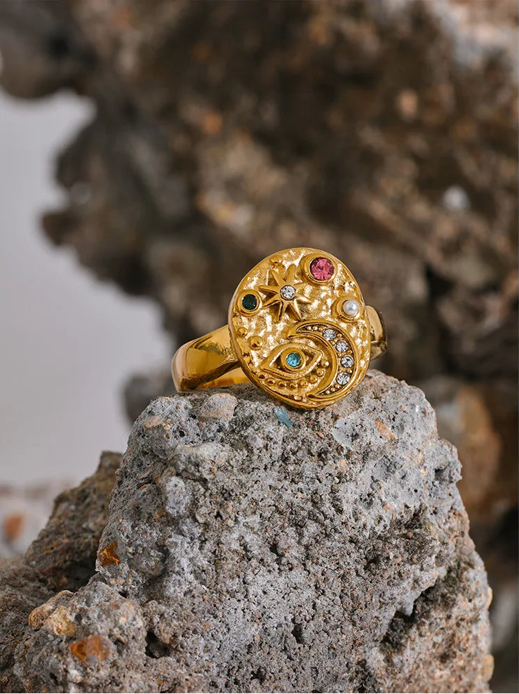 Gold ring with gemstones on a rock